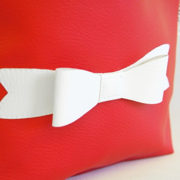 Pochette zippée en simili cuir rouge avec nœud papillon blanc