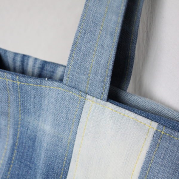 Sac à main en jeans recyclé façon patchwork en bandes verticales.